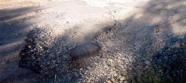 El pavimento presenta baches de envergadura que obligan a los vehículos a esquivarlos generando riesgos entre los conductores que utilizan esta vía para acceder a sus viviendas